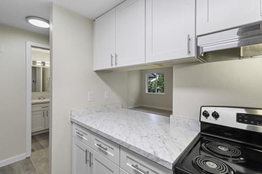 Lovely Kitchen with White Cabinets, Plank Flooring, and Efficient Appliances at Casa Blanca Apartment Homes, Everett, WA, 98204