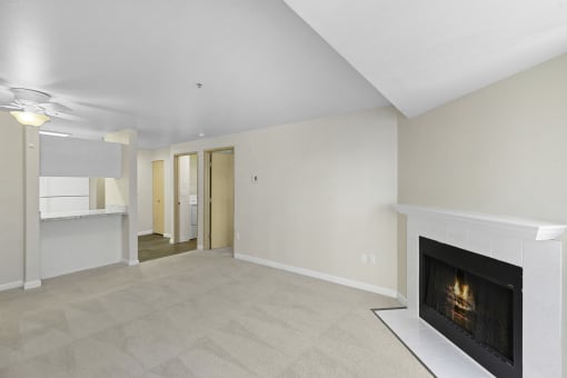 a living room with a fireplace and a kitchen in the background at Casa Blanca Apartment Homes, Everett, WA, 98204
