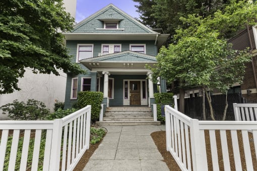 a house with a white fence in front of it  at Charbern Apartment Homes, Seattle, 98122