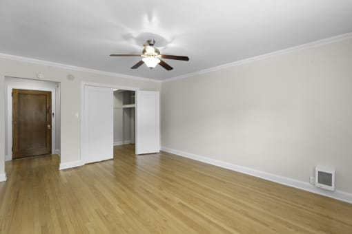 Expansive Living Room with plank flooring and a ceiling fan with light at Charbern Apartment Homes, Seattle, WA, 98122