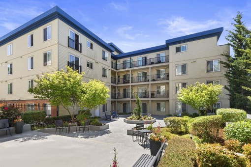 beautiful courtyard with paved area lined with plants and bushes at Guinevere Apartment Homes, Seattle, WA