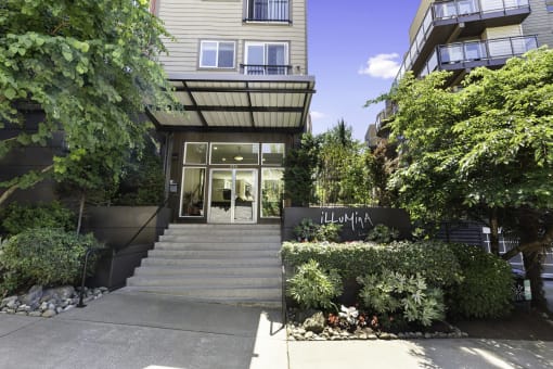 the front of the property building with stairs and bushes in front of it at Illumina Apartment Homes, Seattle