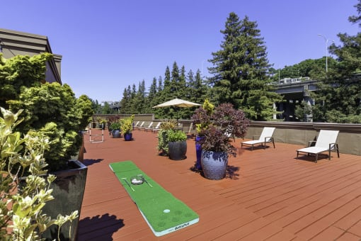 a mini putting green on the resident rooftop deck with trees in the background at Illumina Apartment Homes, Seattle, Washington 98102