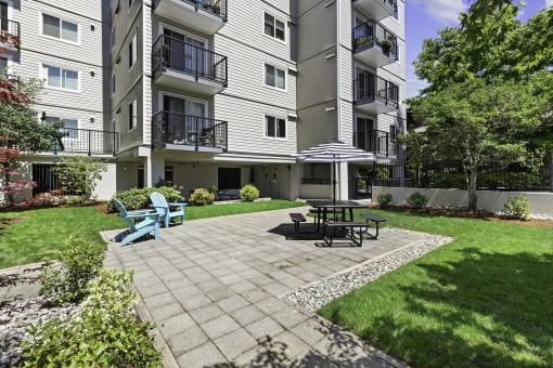 Resident patio space with a table and chairs for relaxing at King Arthurs Court, Seattle