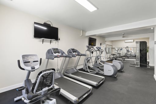 Resident Fitness Center with Cardio equipment and a flat screen tv at Malloy Apartment Homes in Seattle, WA, 98105