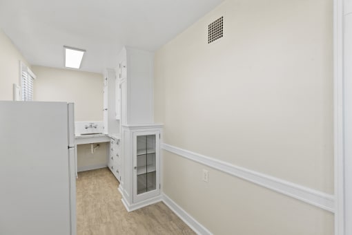 Side View of Kitchen with Small Built-In White Cabinet Area and a Refrigerator at Malloy Apartment Homes in Seattle, WA