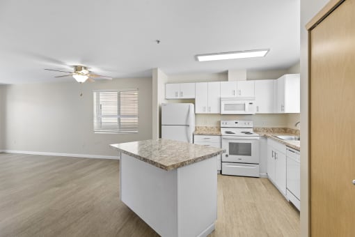 Very Large, Spacious kitchen area with white cabinetry and an island at Promenade at the Park Apartment Homes, WA 98125