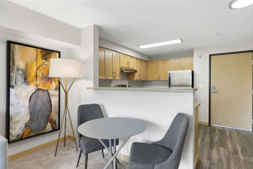Dining Space with cozy set u with a table and two chairs and a kitchen in the background at Villaggio Apartment Homes, Tacoma