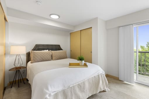 a bedroom with a bed and a sliding glass door with window coverings at Villaggio Apartment Homes, Washington, 98402