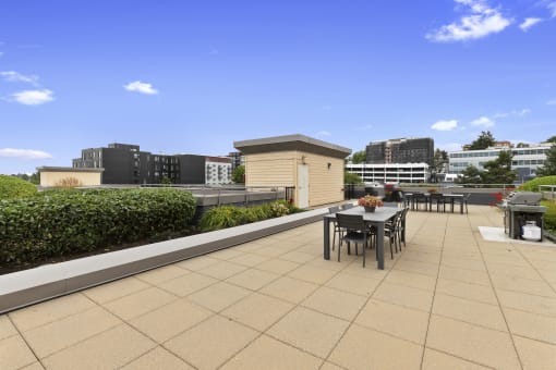 a roof top lounge space with a dining table and chairs at Villaggio Apartment Homes, Washington, 98402