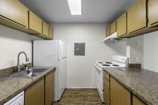 a kitchen with a white refrigerator next to a stove top oven at Willows Court Apartment Homes, Seattle, Washington 98125