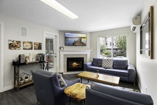 a living room with couches, wooden coffee table, and a fireplace at Willows Court Apartment Homes, Washington, 98125