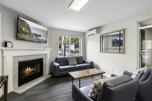 Spacious Living room with cozy seating areas, a coffee table, and a fireplace complete with a mantle at Willows Court Apartment Homes, Washington