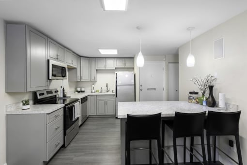a kitchen with gray cabinets and a white counter top at Willows Court Apartment Homes, Seattle, Washington 98125