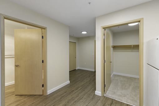 Bedroom with Plank Flooring and a Closet with Plush Carpeting at Excalibur Apartment Homes, Washington