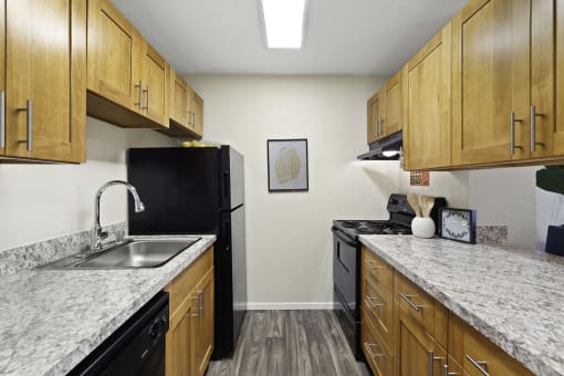 Spacious Kitchen with Plank Flooring, Overhead Lighting, and Light Brown Cabinetry at Pacific Park Apartment Homes, Edmonds, 98026