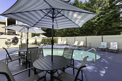 Unique Swimming Pool with Table, Chairs, and Umbrella for Relaxing in the Shade at Park 210 Apartment Homes, Washington