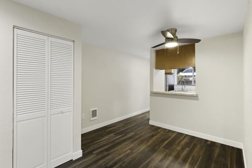 Large Open Living Room with Plank Flooring, a Window Area into the Kitchen and a Coat Closet at Park 210 Apartment Homes, Edmonds, 98026