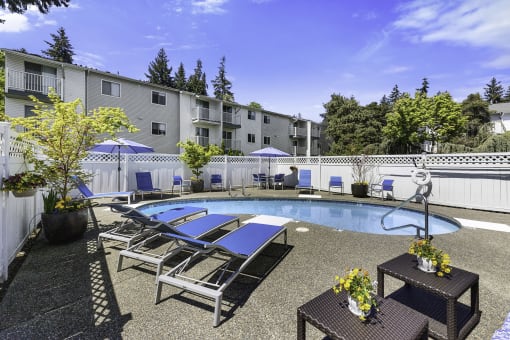a pool with lounge chairs and umbrellas at the enclave at woodbridge apartments in sugar