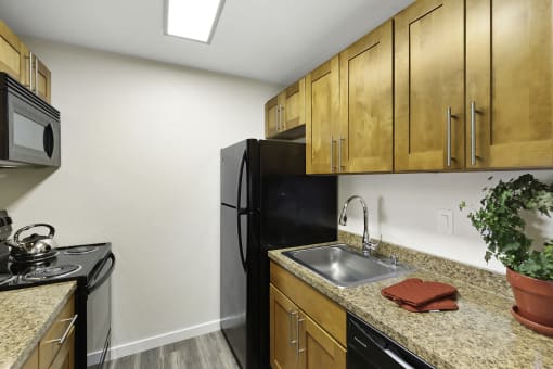 a kitchen with wooden cabinets and black appliances
