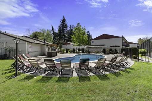 Cool Blue Swimming pool with Lounge Chairs and Grassy Area at Pinewood Square Apartment Homes, Lynnwood