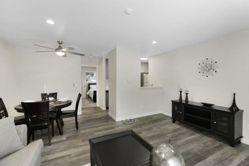 An Inviting Living and Dining Room Area with a Ceiling Fan and Hardwood Floors at Pinewood Square Apartment Homes, Lynnwood