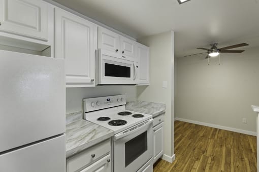 a kitchen with white cabinets and white appliances at Serra Vista Apartment Homes, Lynnwood, 98087