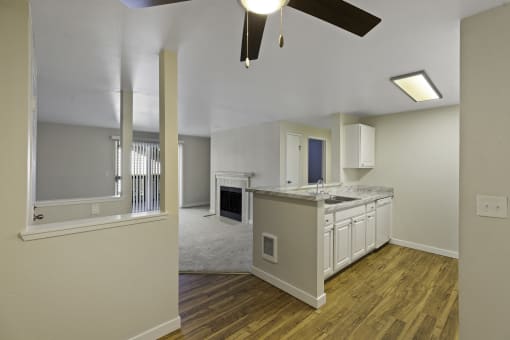 a kitchen and living room in an apartment with a ceiling fan at Serra Vista Apartment Homes, WA 98087
