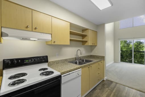a kitchen with wooden cabinets and a white stove top oven at Sir Gallahad Apartment Homes, Bellevue, 98004