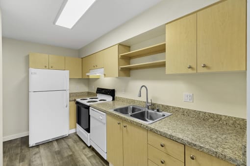 Modern Style Kitchen with Wooden Cabinetry, Plank Flooring, and White Refrigerator at Sir Gallahad Apartment Homes, Bellevue, Washington 98004