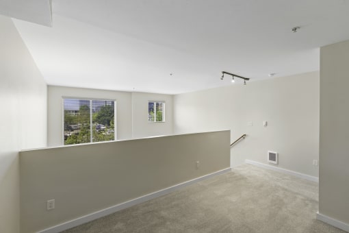 Second Floor Loft Bedroom with Large Windows and Plush Carpet Flooring at Sir Gallahad Apartment Homes, WA 98004