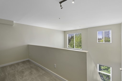 Loft-Style Bedroom with Wall to Wall Carpeting, and Multiple Window Views at Sir Gallahad Apartment Homes, Bellevue, 98004
