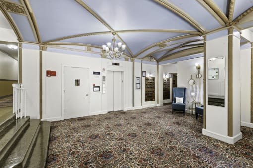 a large lobby with a vaulted blue ceiling and chandeliers at Stockbridge Apartment Homes, WA 98101