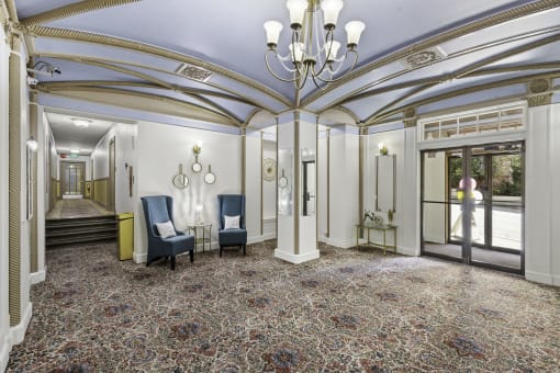 a large cozy lobby area with a chandelier and blue chairs at Stockbridge Apartment Homes, Seattle, WA