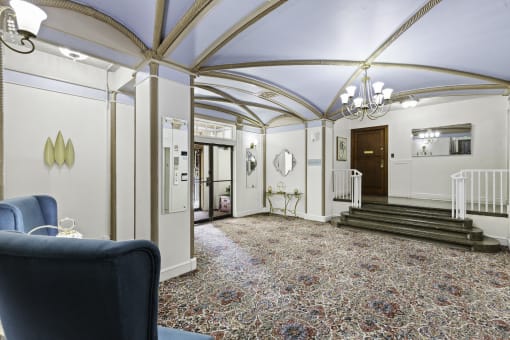 a large lobby area with blue vaulted ceilings with delicate gold detailing and a chandelier at Stockbridge Apartment Homes, Seattle, 98101