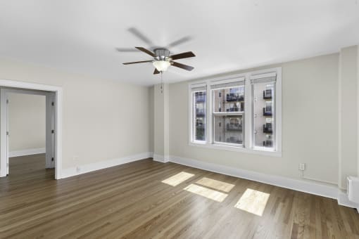 A Living Space with hardwood floors, large windows, and a ceiling fan at Stockbridge Apartment Homes, Seattle, WA