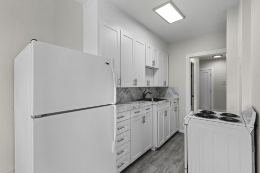 a kitchen with white cabinets and white appliances at Stockbridge Apartment Homes, Seattle, Washington 98101