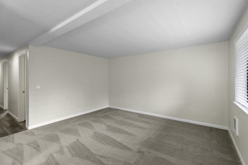 a bedroom with tan walls and a gray carpet at Swiss Gables Apartment Homes, WA 98032