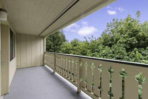 a large balcony with a view of the treeline at Swiss Gables Apartment Homes, WA 98032