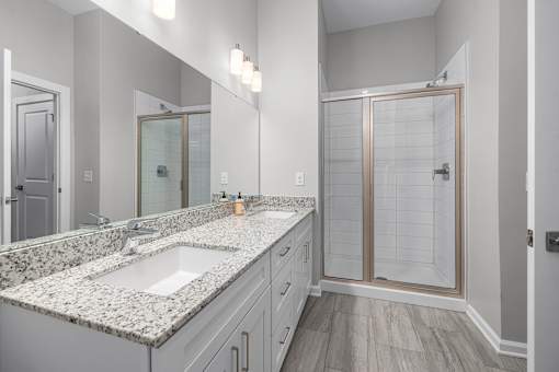 a bathroom with a large mirror and a shower with a glass door  at Griffin Weston, North Carolina