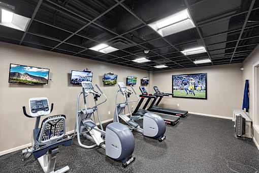 A gym with a row of exercise bikes and treadmills at MainCentre, Northville