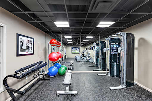 A gym with a variety of equipment including a bench, weights, and a rowing machine at MainCentre, Northville