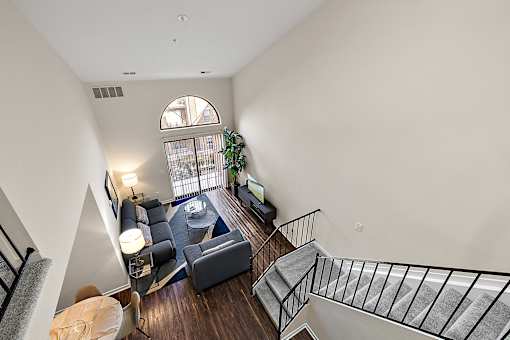A living room with a couch, a chair, a coffee table, and a staircase at MainCentre, Northville