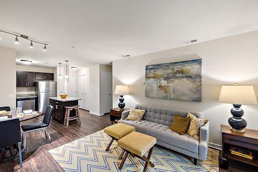A living room with a grey couch and a painting on the wall at MainCentre, Northville