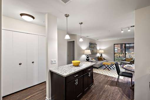 A kitchen with dark wood cabinets and a granite countertop at MainCentre, Northville