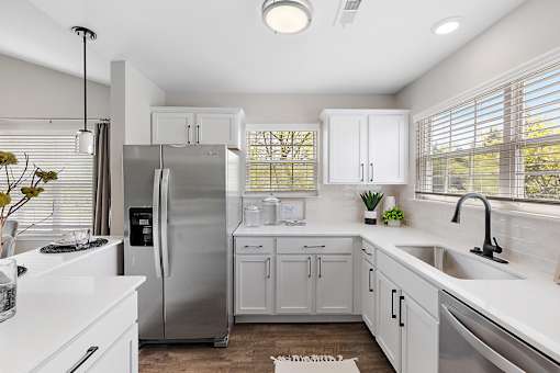 A modern kitchen with white cabinets and a stainless steel refrigerator at Briarcliff Village, Michigan, 48390