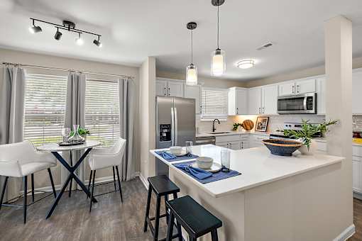 A kitchen with a table and chairs by a window at Briarcliff Village, Michigan, 48390