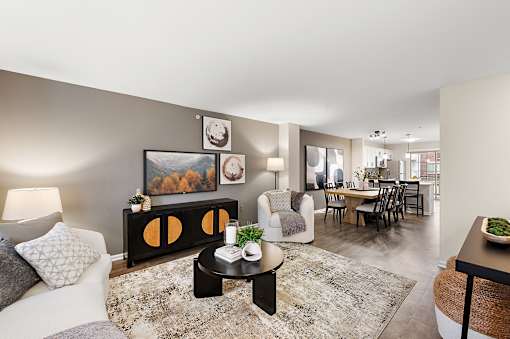 A living room with a grey couch, a coffee table, and a painting on the wall.