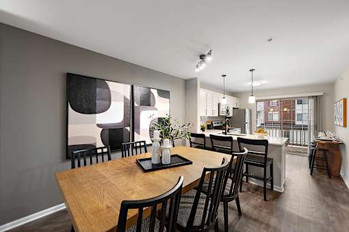 A modern dining room with a wooden table and chairs.