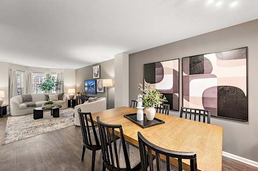 A modern dining room with a wooden table and chairs.